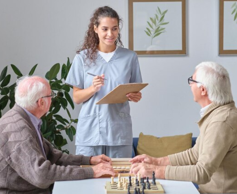 Nurse talking to senior men in nursing home Nurse talking to senior men in nursing home